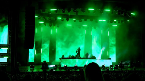 Man on stage with green lights 