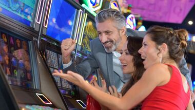Three People at the slot machines cheering